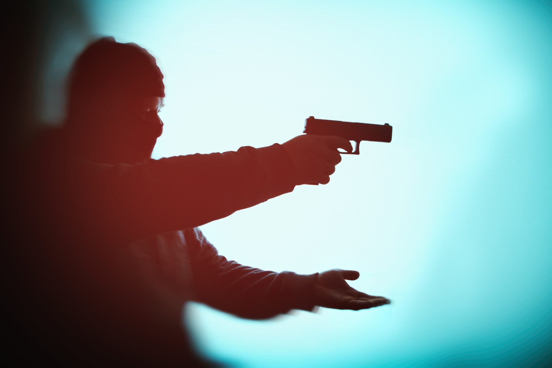 malfaiteur pointant une arme à feu